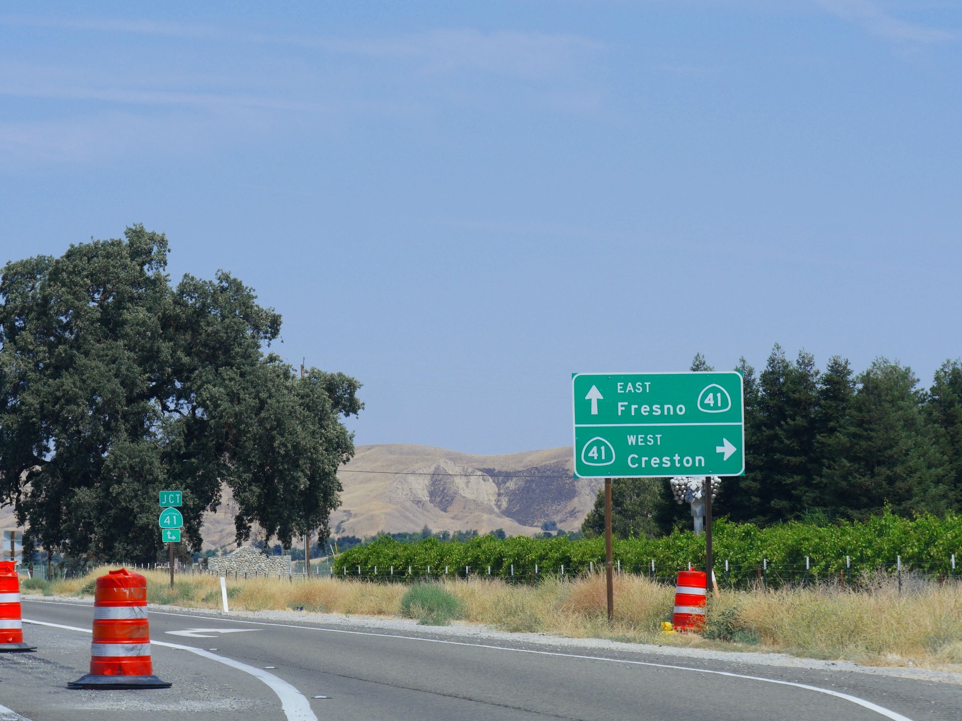 Roadside signs along Highway 46 with directions to Fresno and Creston, California.